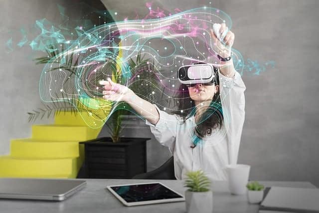 woman with VR headset with her arms outstretched, there's a holographic-like map that it looks like she is manipulating.