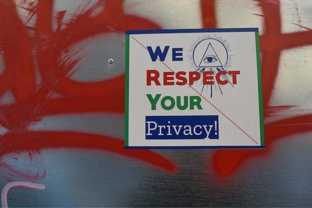 Sign on a wall that has red graffiti and a sign that says 