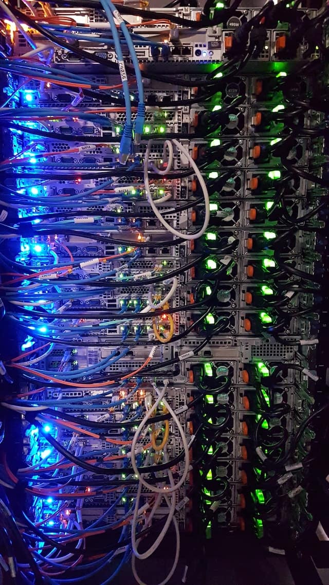 massimo-botturi-zFYUsLk_50Y-unsplash Server Room with a large rack of servers and network devices.